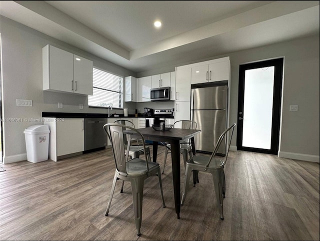 kitchen featuring sink, appliances with stainless steel finishes, white cabinetry, and hardwood / wood-style flooring