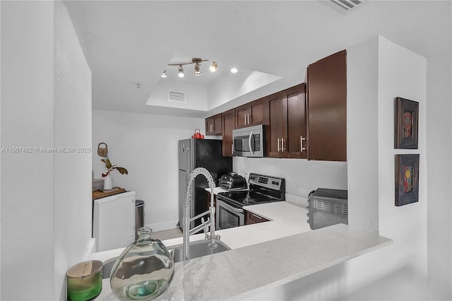 kitchen with dark brown cabinetry, kitchen peninsula, sink, and appliances with stainless steel finishes