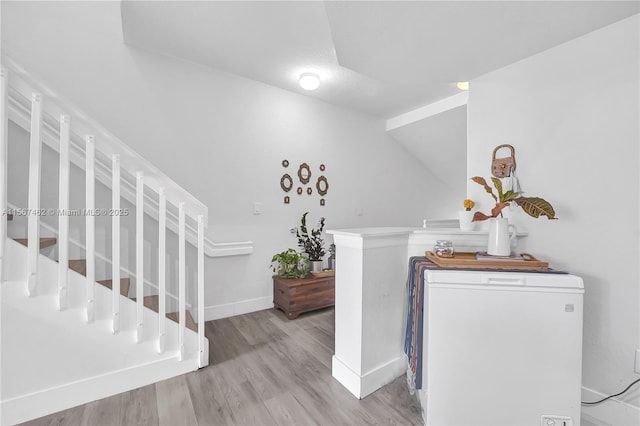 foyer entrance featuring light hardwood / wood-style floors and vaulted ceiling