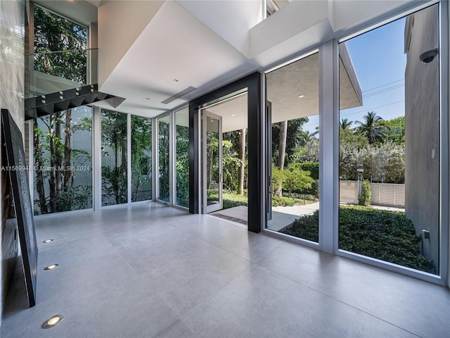 interior space with floor to ceiling windows, plenty of natural light, and a high ceiling