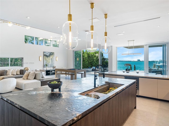 kitchen with sink, a wealth of natural light, and a kitchen island with sink