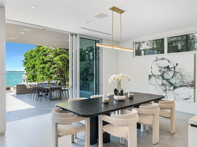 dining area with a wall of windows and a water view