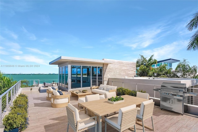 deck with an outdoor living space, a water view, and a grill