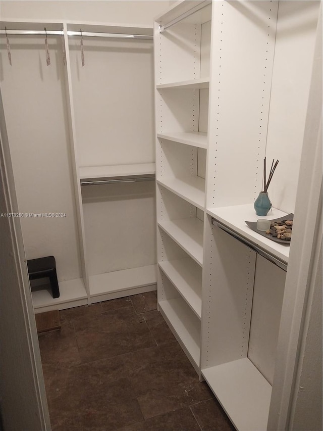 spacious closet with dark tile patterned flooring