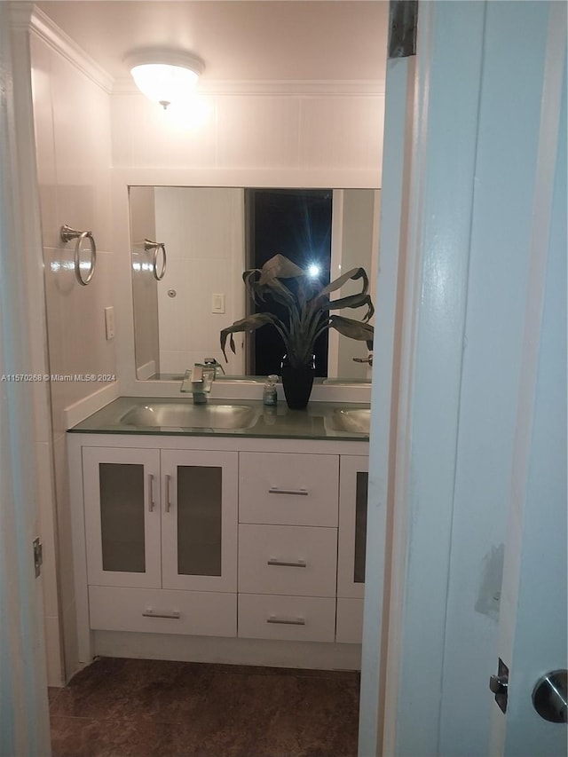 bathroom with dual vanity, crown molding, and tile patterned flooring