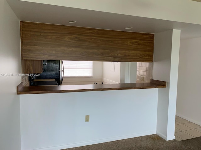 kitchen with fridge and carpet