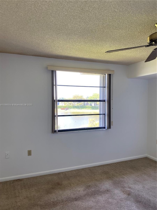 unfurnished room featuring a ceiling fan, baseboards, a textured ceiling, and carpet floors
