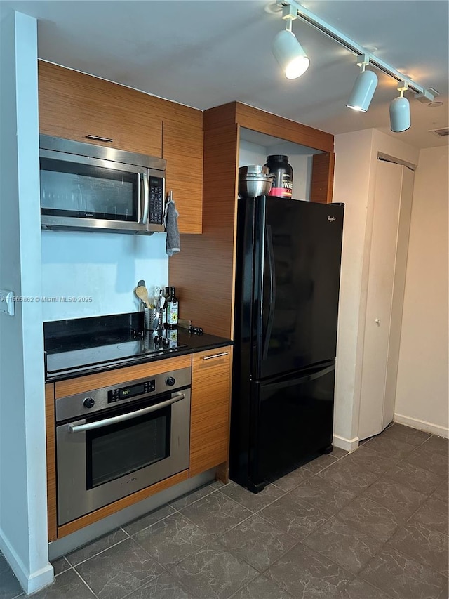 kitchen with rail lighting and black appliances