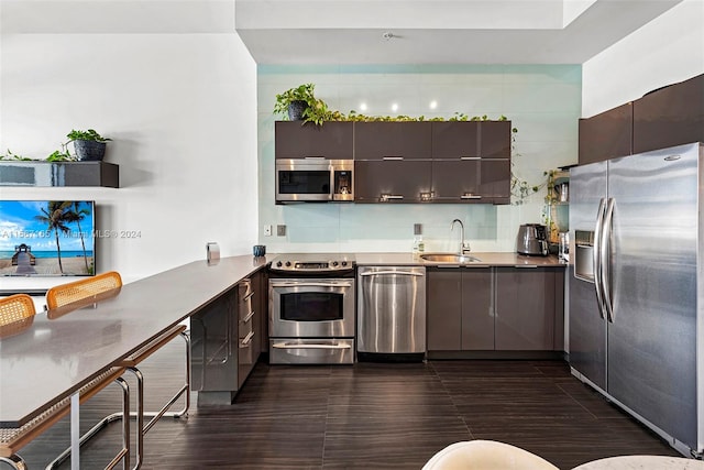 kitchen featuring beverage cooler, dark hardwood / wood-style flooring, appliances with stainless steel finishes, dark brown cabinets, and sink