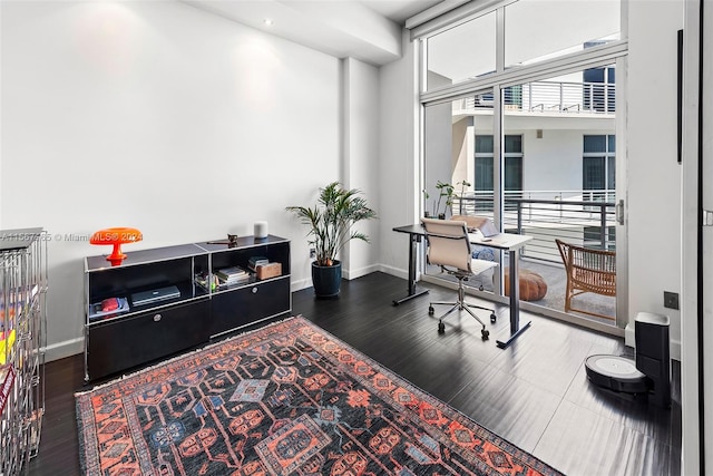 office with dark hardwood / wood-style flooring and a towering ceiling