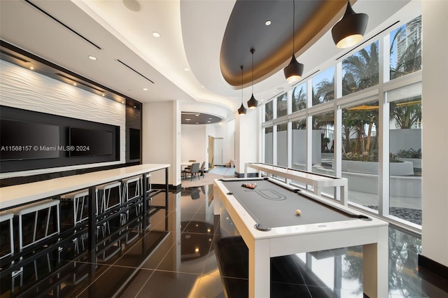 rec room featuring a raised ceiling, dark tile patterned floors, and pool table