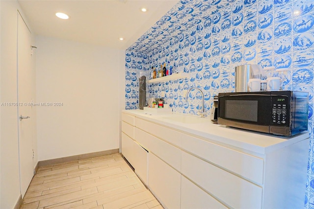 interior space featuring sink, white cabinets, and light hardwood / wood-style flooring