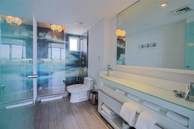 bathroom featuring vanity, toilet, walk in shower, a notable chandelier, and wood-type flooring