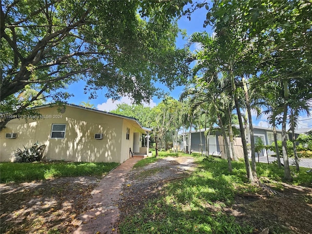 view of side of property with fence and stucco siding