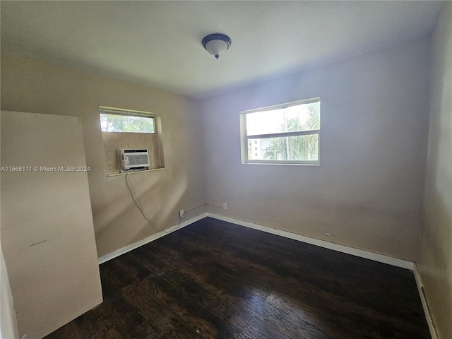 spare room with dark wood-style floors, baseboards, and cooling unit