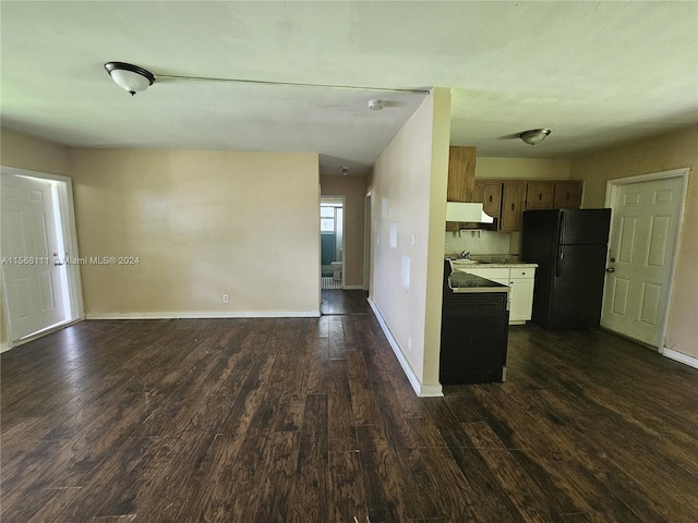 kitchen with open floor plan, dark wood finished floors, freestanding refrigerator, and under cabinet range hood