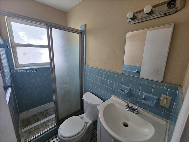 full bath with tile walls, toilet, a wainscoted wall, a shower stall, and a sink