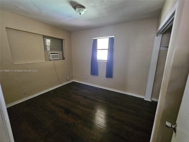 unfurnished bedroom featuring cooling unit, wood finished floors, and baseboards