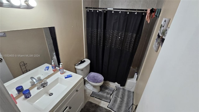 bathroom with tile floors, vanity, and toilet