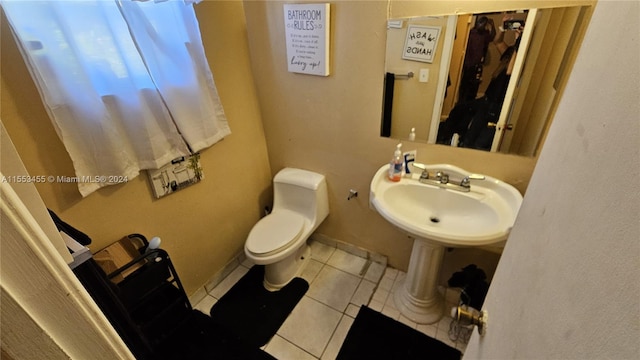 bathroom with sink, tile floors, and toilet