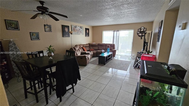 tiled dining space featuring ceiling fan and a textured ceiling