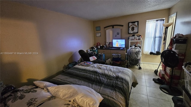 bedroom featuring a textured ceiling and light tile flooring