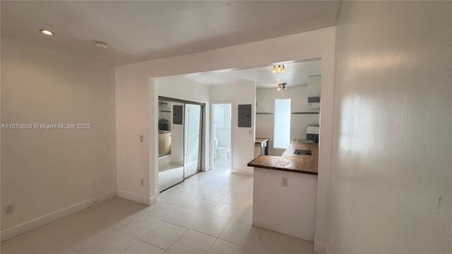 kitchen featuring electric panel and light tile patterned floors