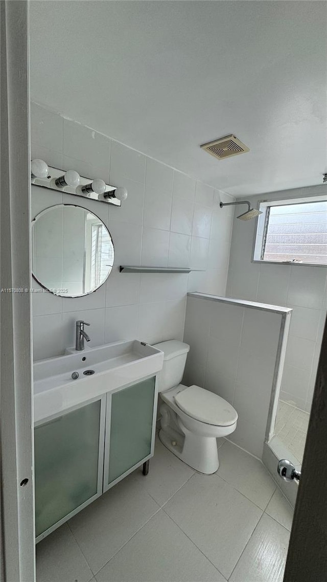 bathroom featuring tile patterned floors, toilet, tile walls, backsplash, and vanity