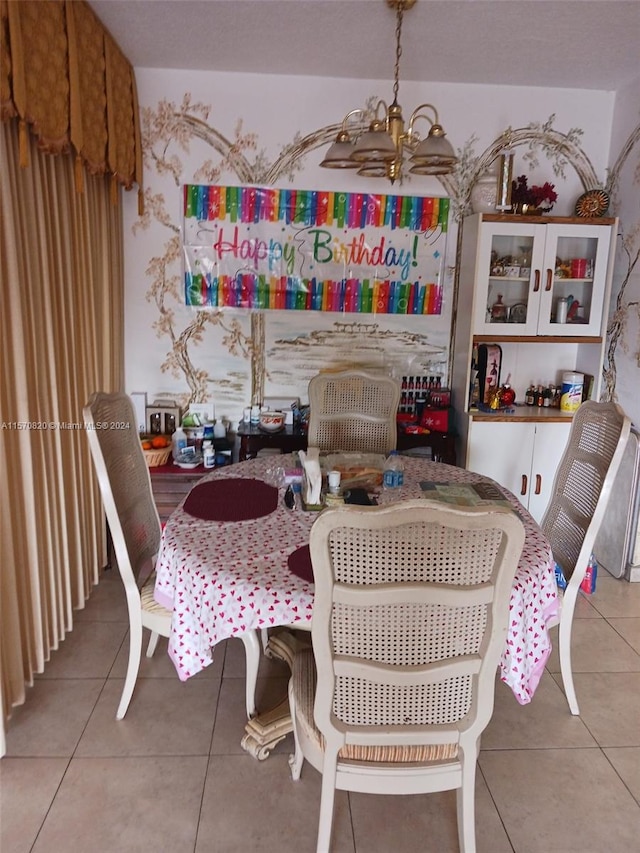 dining room with a notable chandelier and light tile floors