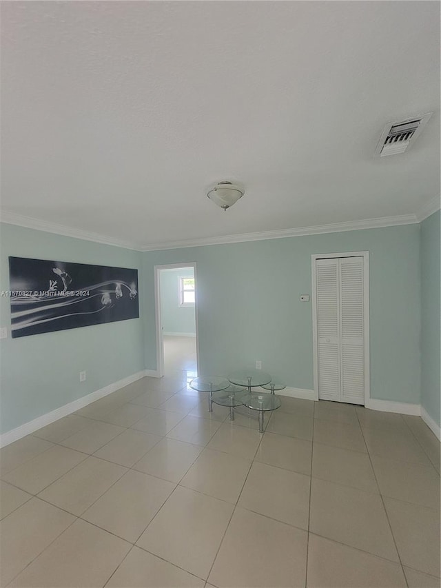 unfurnished room with crown molding and tile patterned flooring