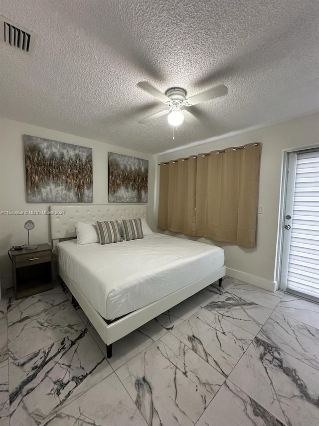 bedroom featuring a textured ceiling, ceiling fan, and light tile floors