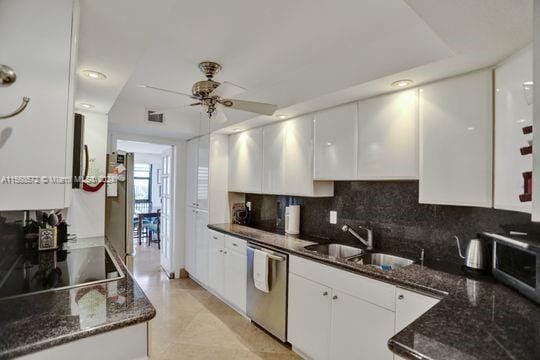 1121 Crandon Blvd Unit F906, Key Biscayne, FL 33149 - kitchen featuring dark stone counters, stainless steel appliances, ceiling fan, a sink, and white cabinetry