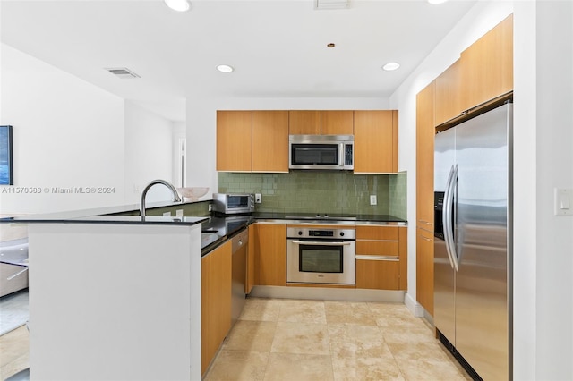 kitchen with appliances with stainless steel finishes, tasteful backsplash, kitchen peninsula, and light tile floors