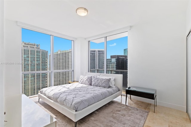 tiled bedroom featuring a wall of windows