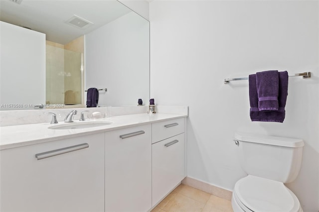 bathroom featuring tile floors, vanity, and toilet