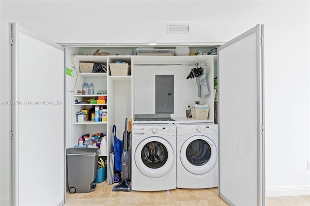 clothes washing area with washing machine and dryer and light tile floors