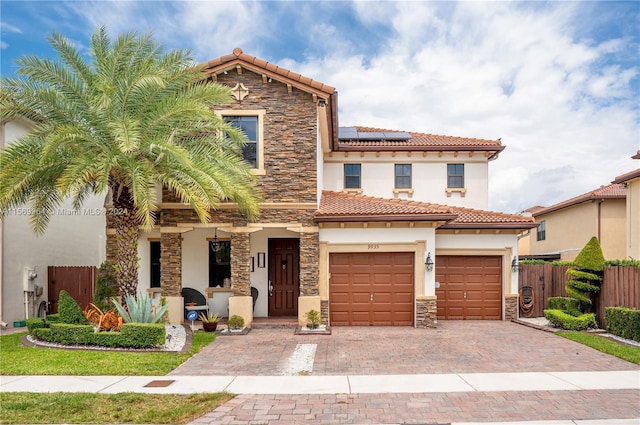 mediterranean / spanish-style house featuring solar panels and a garage