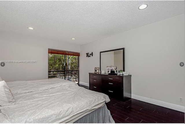 bedroom featuring a textured ceiling, dark wood-type flooring, and access to outside