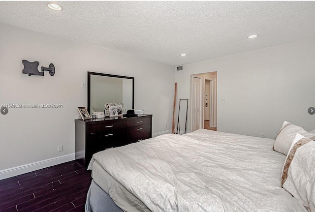 bedroom featuring dark hardwood / wood-style floors and a textured ceiling