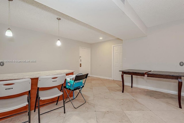 dining space with a textured ceiling and light tile floors