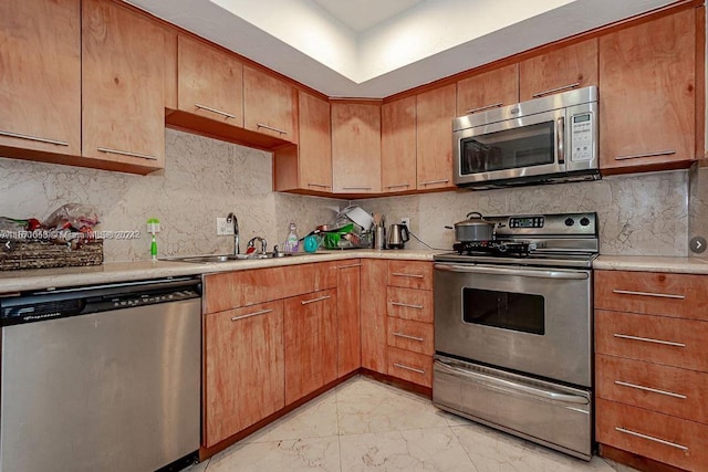 kitchen with tasteful backsplash, appliances with stainless steel finishes, light tile floors, and sink