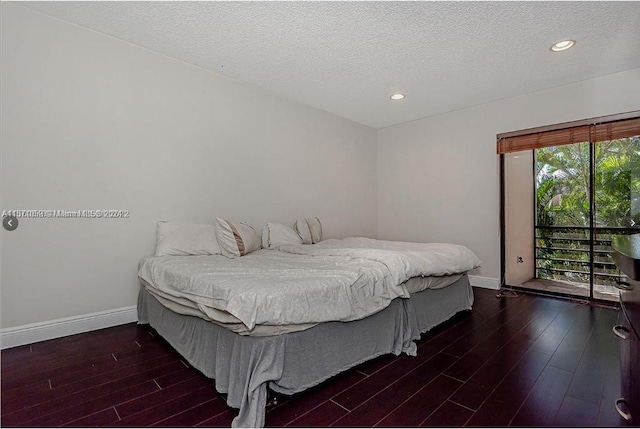 bedroom with multiple windows, dark hardwood / wood-style floors, and a textured ceiling