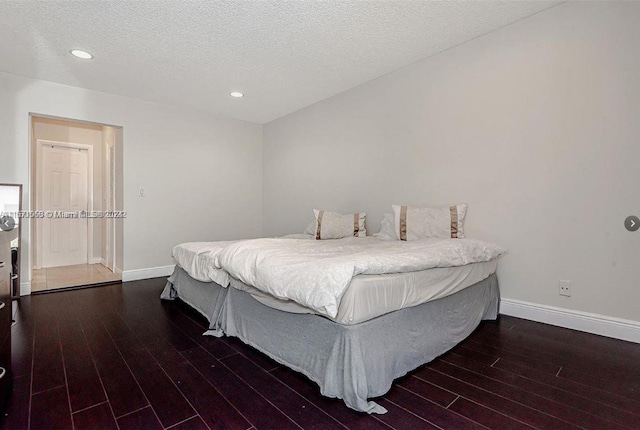 bedroom with dark hardwood / wood-style flooring and a textured ceiling