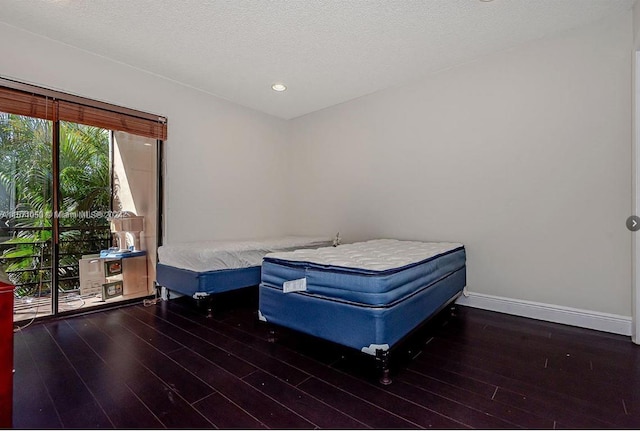 bedroom with dark wood-type flooring and a textured ceiling