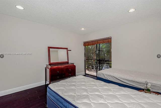 bedroom featuring hardwood / wood-style flooring, access to outside, and a textured ceiling