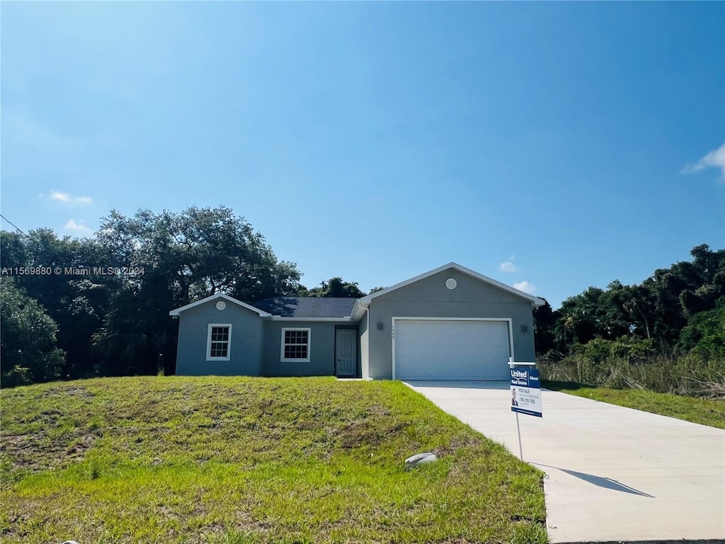 ranch-style home with a garage and a front lawn