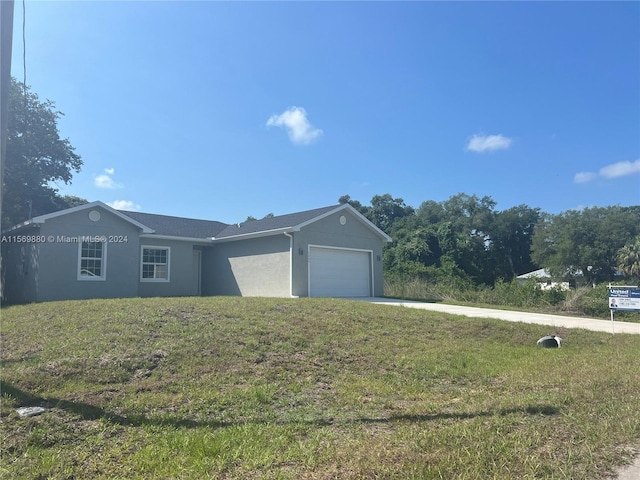 view of front of home with a garage and a front lawn