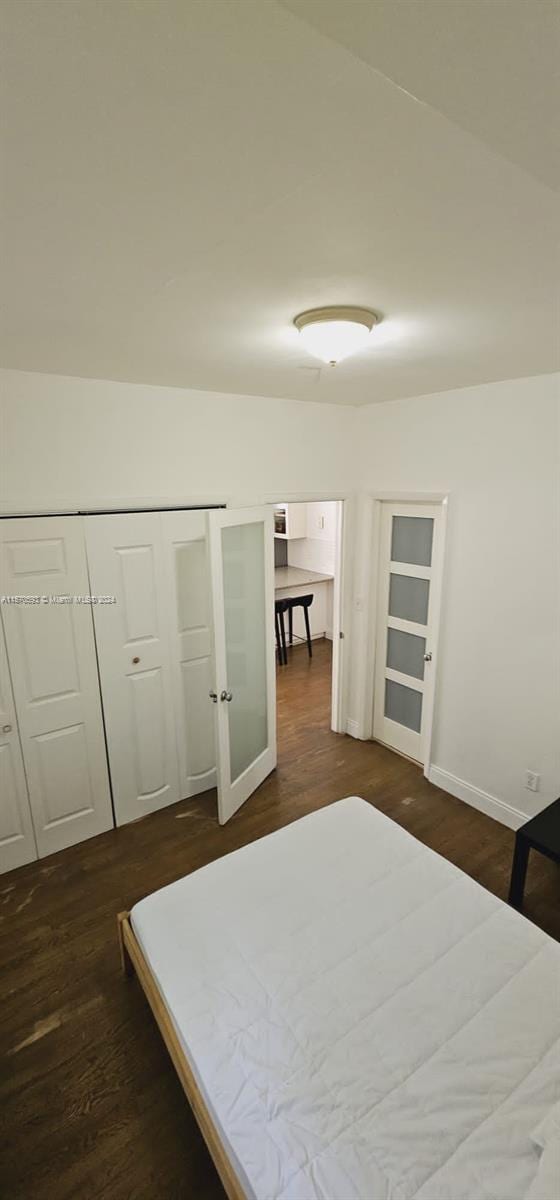 bedroom with a closet and dark wood-type flooring