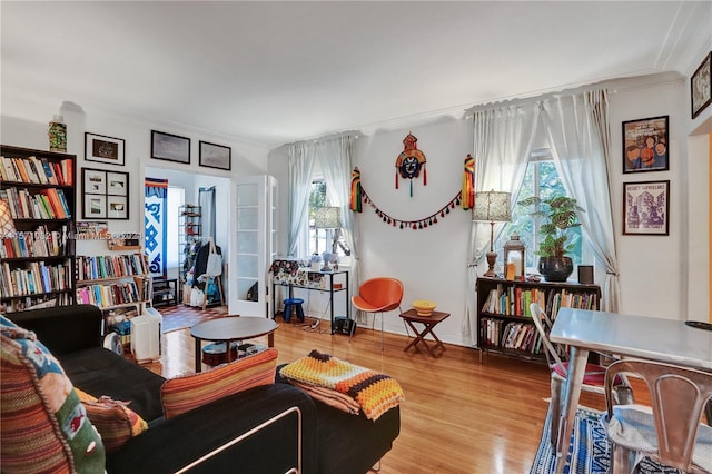 living room with light hardwood / wood-style flooring and ornamental molding