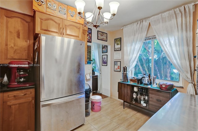 kitchen with pendant lighting, an inviting chandelier, light tile floors, and stainless steel fridge